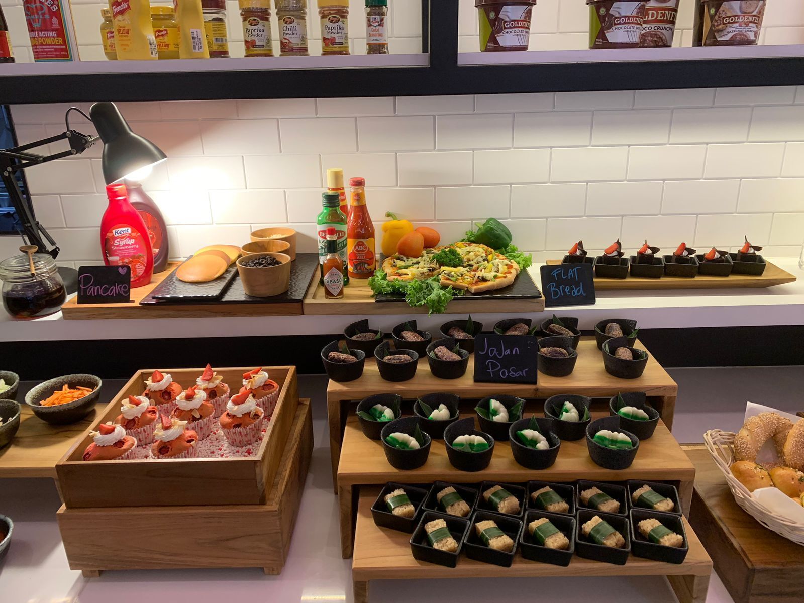 Une présentation de produits alimentaires comprenant divers articles, notamment des crêpes, du pain et des desserts.