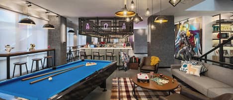 Una sala de estar moderna con mesa de billar, sofá y mesa de centro.
