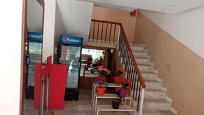 Un escalier avec une rampe en bois et une barrière rouge en bas.