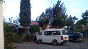 A white van parked in a driveway with a house in the background.