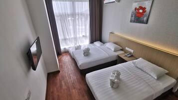 A hotel room with two beds, a bedside table with a phone, a wall-mounted air conditioner, and a painting on the wall.