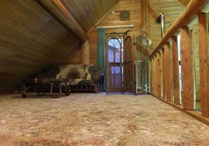 Cozy attic retreat with a vintage bed, ornate door, and outdoor access.