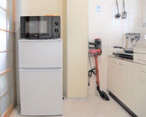 Kylskåp, mikrovågsugn, spishäll och grytor/köksredskap