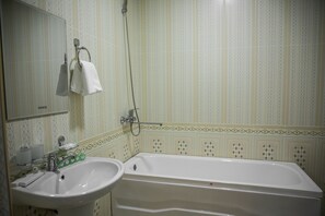 A bathroom with a sink, mirror, and bathtub. - Hotel Minor (Samarkand)