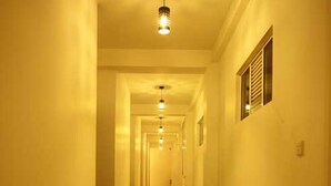 A long, well-lit hallway with a tiled floor and ceiling lights. - Sanoreech Hotel (Negombo)
