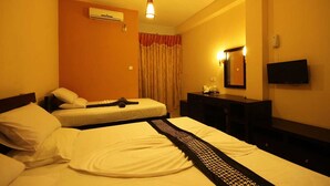 A hotel room with two beds, a desk, a chair, a TV, and an air conditioning unit. - Sanoreech Hotel (Negombo)