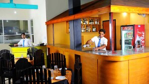 A bar area with a counter, seating, and a Coca-Cola refrigerator. - Sanoreech Hotel (Negombo)