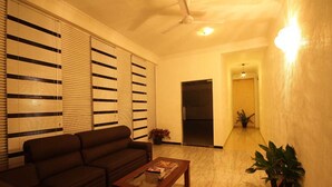 A living room with a sofa, a coffee table, and a potted plant. - Sanoreech Hotel (Negombo)