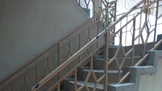 A staircase with a metal railing and tiled walls. - Liwa Guest House (Naivasha)
