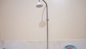 A shower with a handheld showerhead and a wall-mounted faucet. - Liwa Guest House (Naivasha)