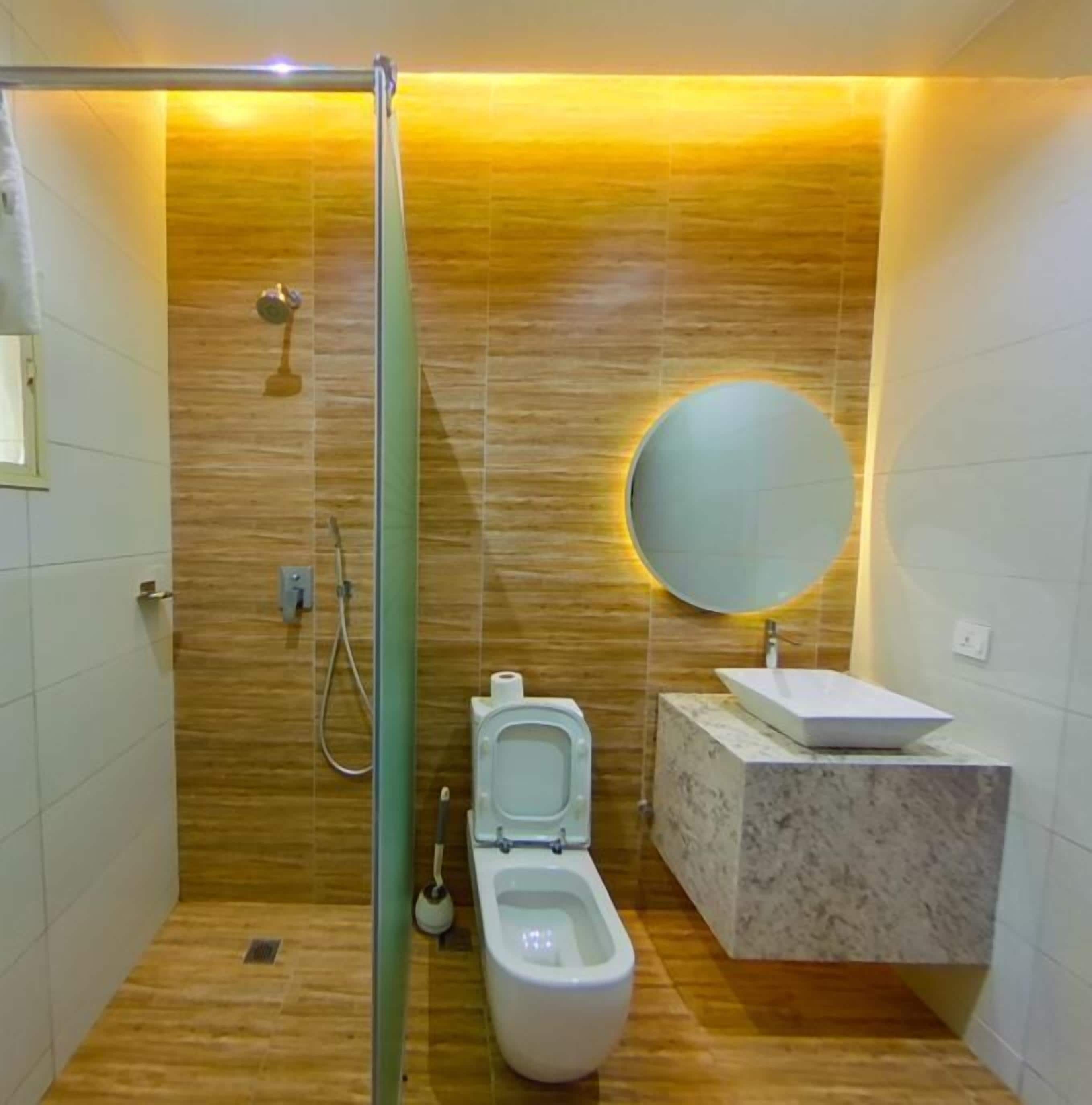 Une salle de bain moderne équipée de toilettes, d’un bidet et d’un lavabo doté d’un plan de travail en marbre.