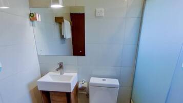 Une salle de bain avec des toilettes, un lavabo et un miroir.