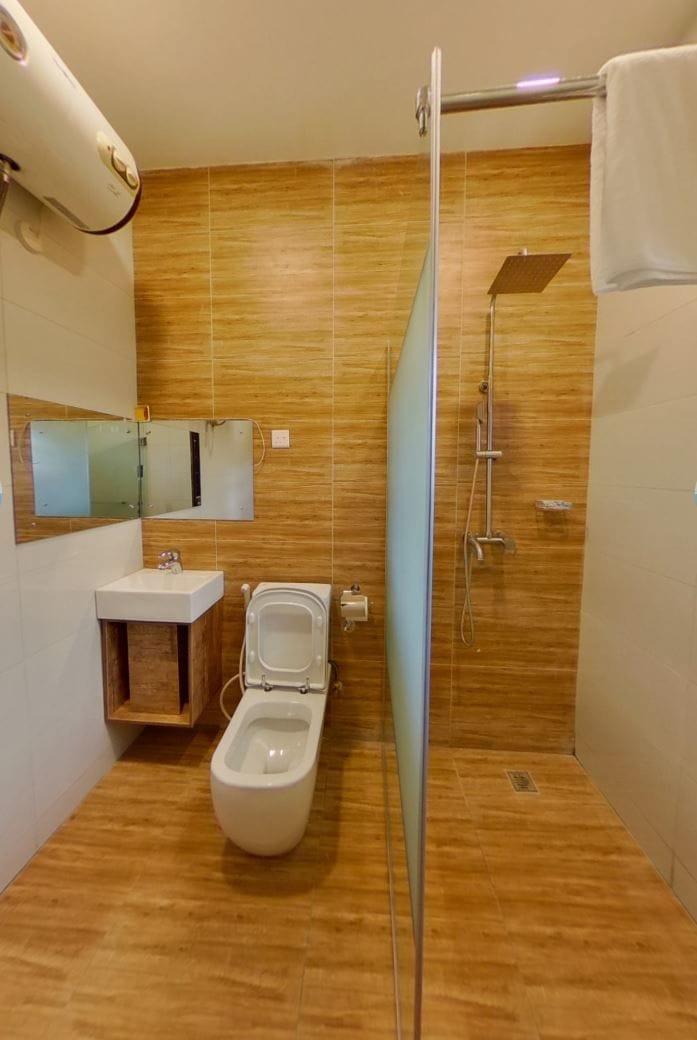 A bathroom with a toilet, sink, and shower.