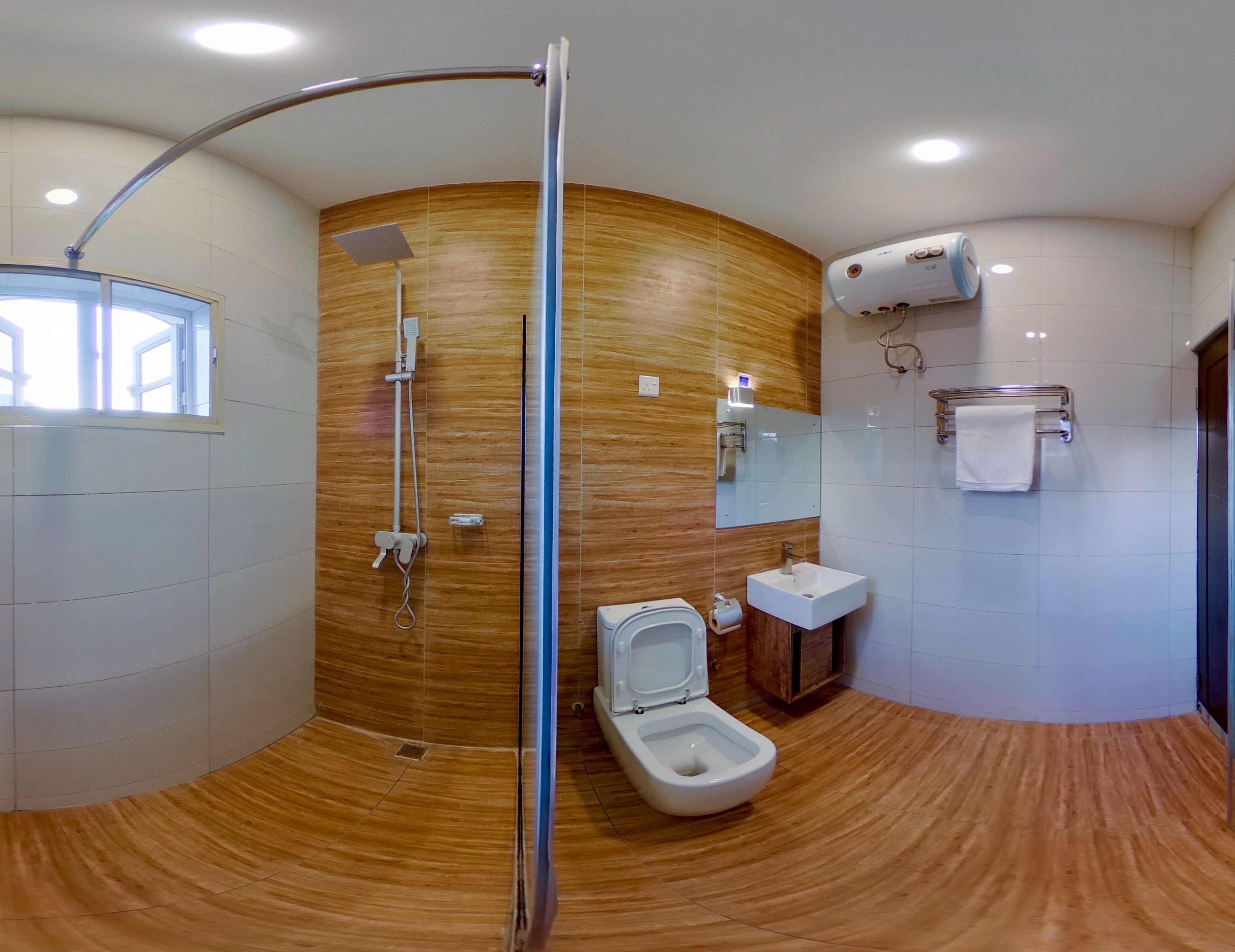 A modern bathroom with a wooden accent wall, a shower, a toilet, a sink, and a towel rack.