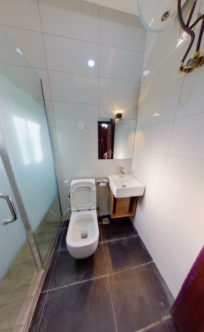 A modern bathroom with a toilet, sink, and glass shower enclosure.