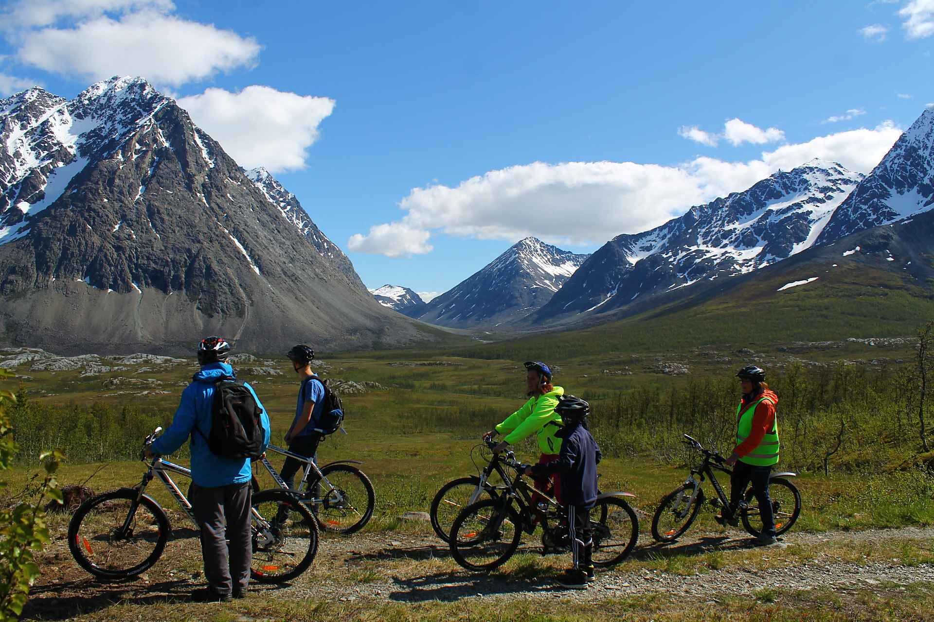 Un grupo de personas con bicicletas en un paisaje montañoso.