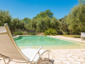 A swimming pool with a lounge chair in the foreground, surrounded by trees and greenery. - Nice cottage full of charm in a vineyard with large swimming pool (Murviel les Beziers)