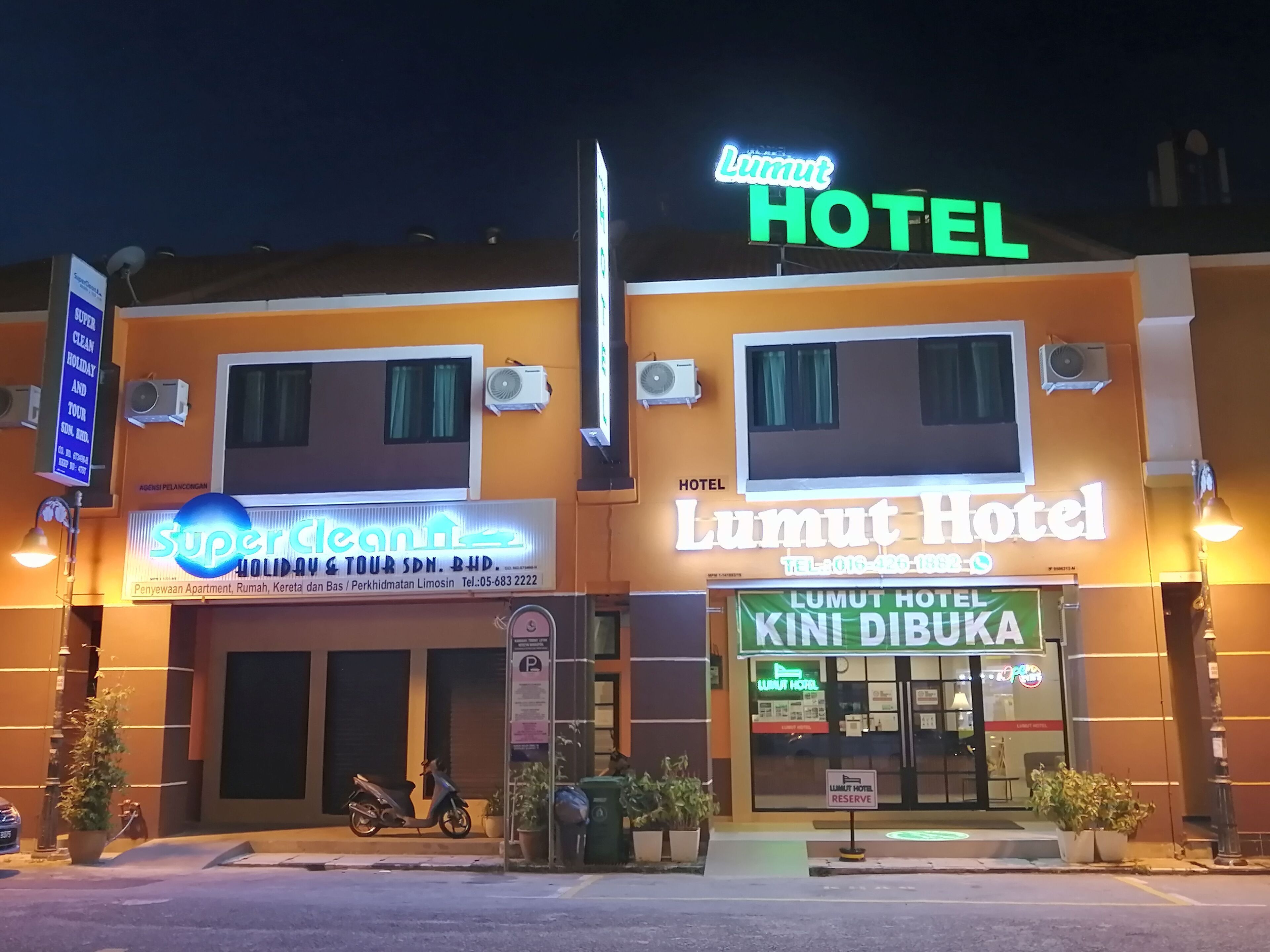 A hotel with a prominent 'Lumut Hotel' sign, a 'SuperClean' sign, and a 'Kini Dibuka' sign indicating the restaurant is open.