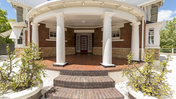 A building with a covered entrance, columns, and a brick facade. - White Rocks (Tanunda)
