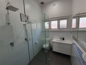 A modern bathroom with a glass-enclosed shower, a white sink, and a toilet. - White Rocks (Tanunda)