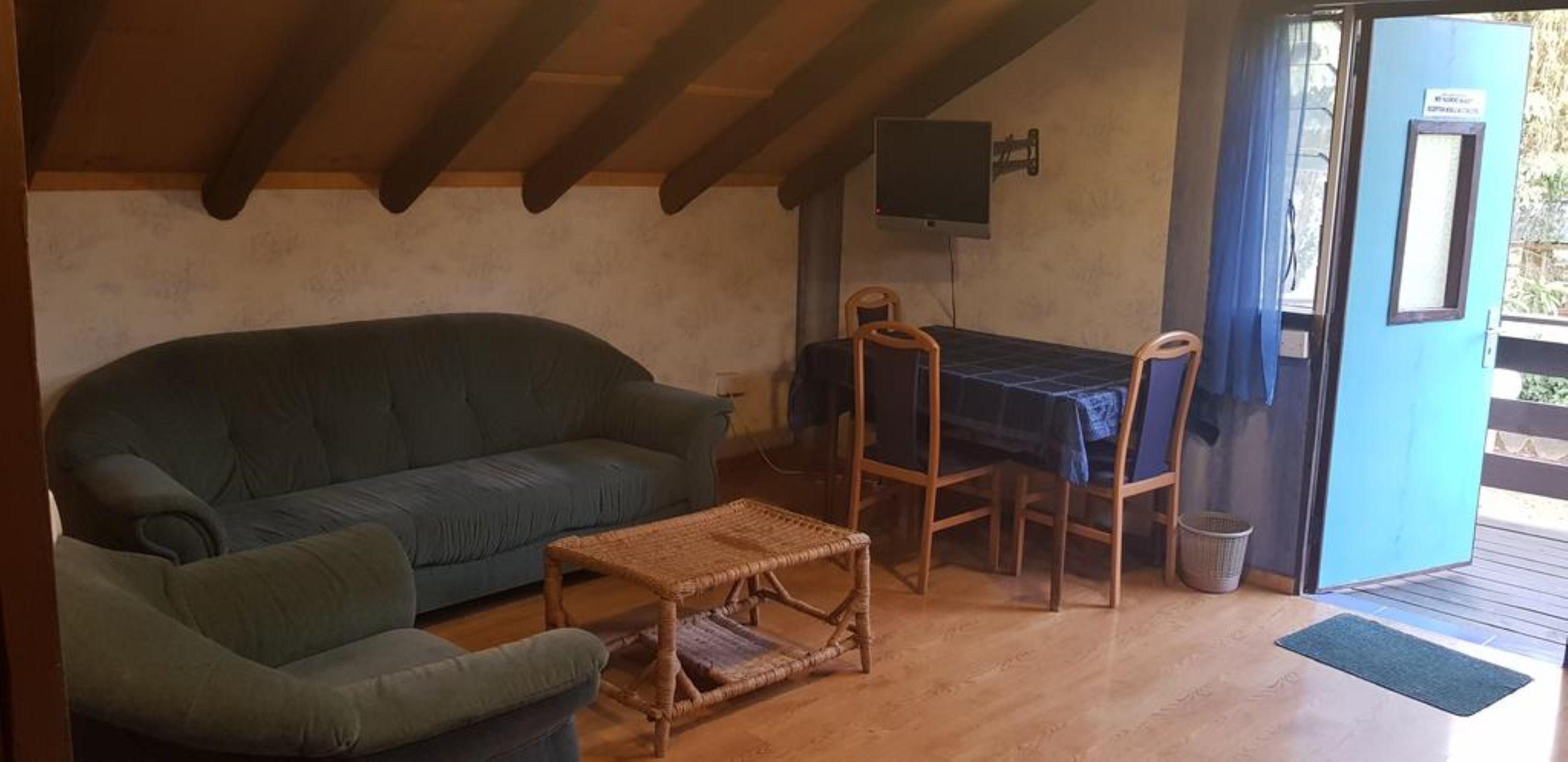 Uma área de estar aconchegante, com um sofá, uma mesa pequena e um conjunto de jantar.