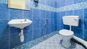 A bathroom with blue patterned tiles, a white sink, and a toilet. - OYO 89461 CP Hotel (Butterworth)