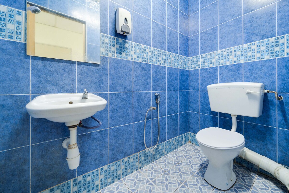 A bathroom with blue patterned tiles, a white sink, and a toilet.