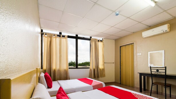 A hotel room with two beds, a desk, and a chair. - OYO 89461 CP Hotel (Butterworth)