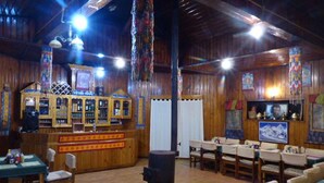 A rustic interior with wooden walls, a bar area, and tables and chairs arranged for dining. - Lukla Airport Resort, Lukla  (Lukla)