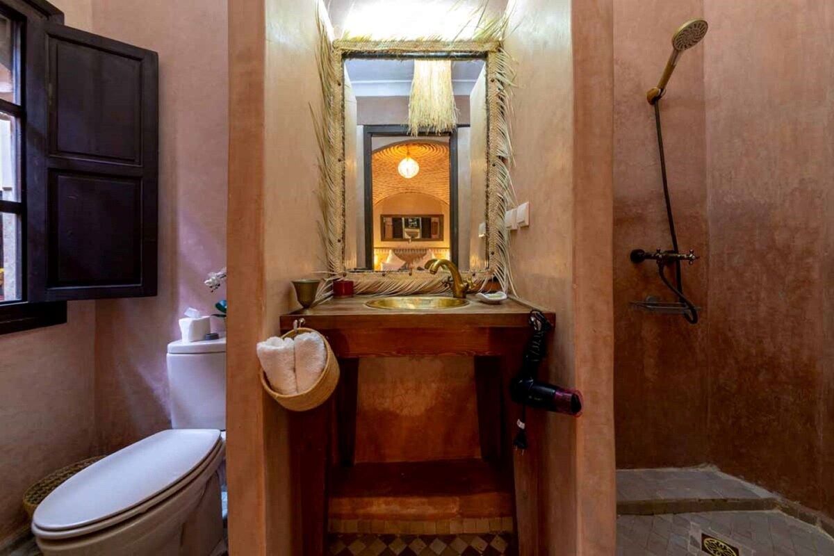 A compact bathroom with a toilet, sink, and shower.