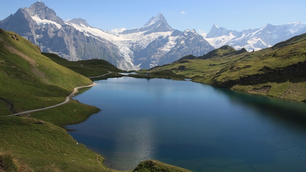 A mountain landscape with a lake and snow-capped peaks. - Hotel Sonnenberg (Grindelwald)
