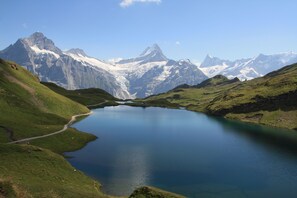 A mountain landscape with a lake and snow-capped peaks.