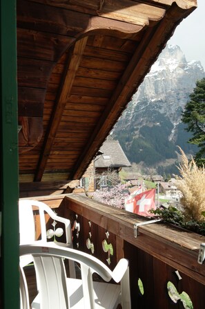 A wooden balcony with a view of a mountain. - Hotel Sonnenberg (Grindelwald)