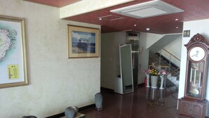Eine Lobby mit einer Karte, einem gerahmten Bild, einer Uhr und einer Treppe.