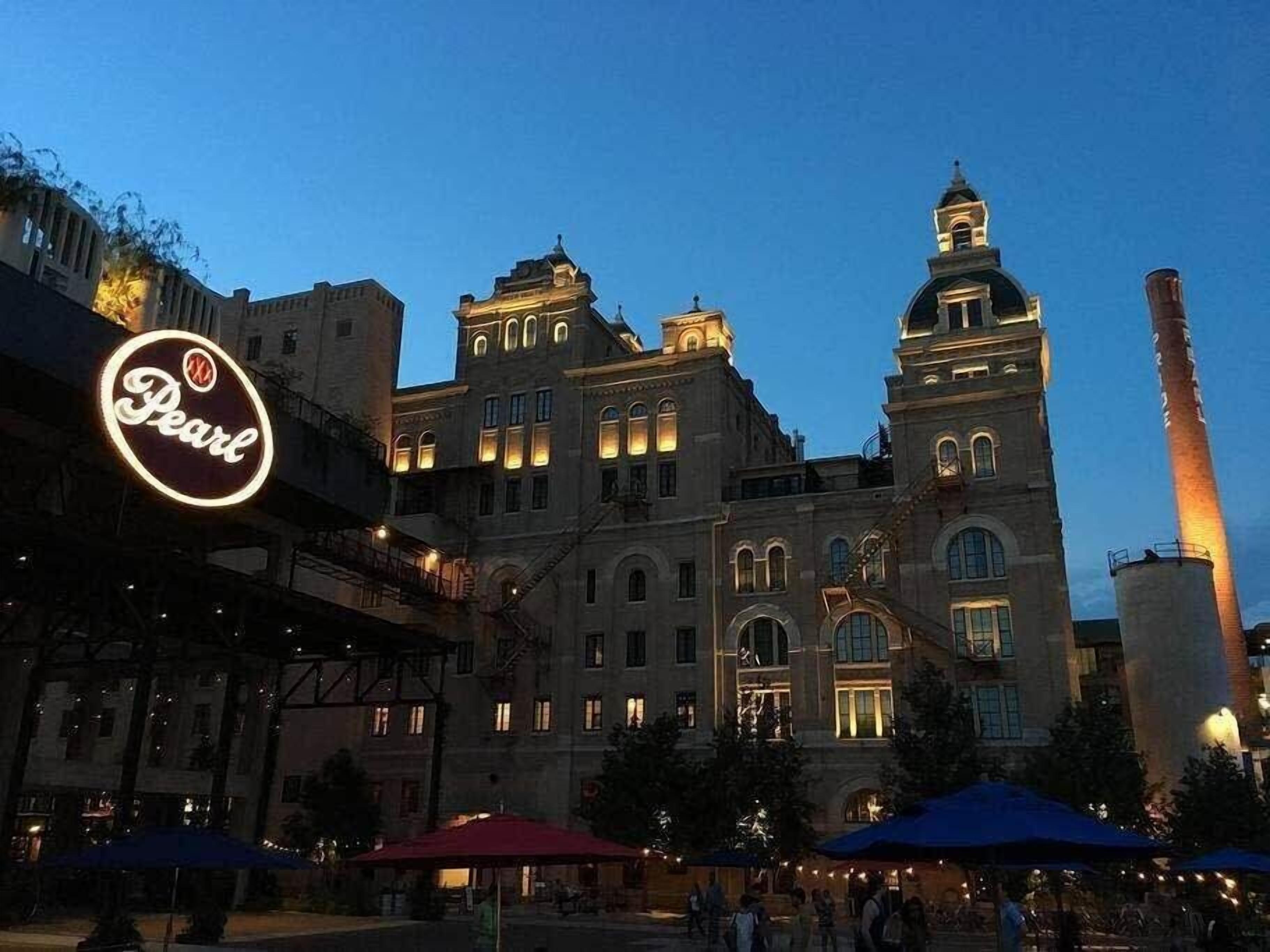 Um edifício histórico com uma torre do relógio imponente e um grande letreiro iluminado com a palavra 