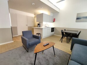 A compact living space with a kitchenette, a dining area, and a seating area with a small table and armchairs. - Forenom Aparthotel Varkaus (Varkaus)