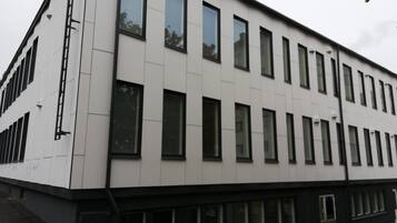 Moderni rakennus, jossa on tasainen julkisivu, useita ikkunoita ja selkeästi erottuva sisäänkäynti.
