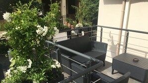 An outdoor seating area with wicker furniture and potted plants. - Les chambres d'Orsay (Orsay)