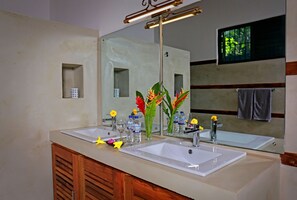 A bathroom with two sinks, a mirror, and a wooden cabinet.