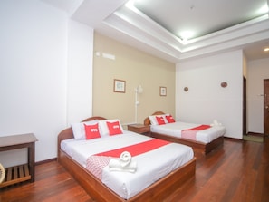 A hotel room with two beds, each with red and white bedding, wooden headboards, and a small bedside table. - OYO 89537 Fairy Garden Resort (Ranau)