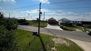 A road with a building on the right and a utility pole in the foreground.