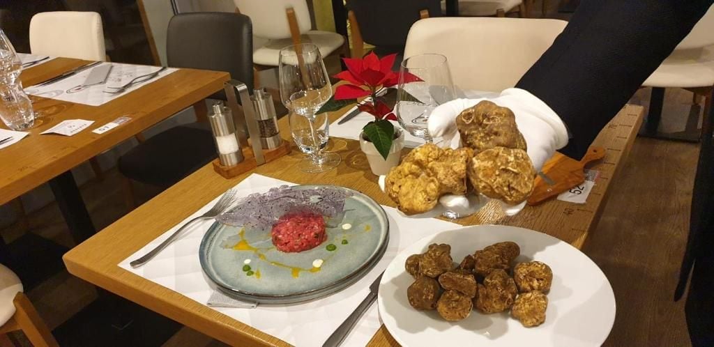 Un tavolo imbandito con piatti di cibo, posate e un bicchiere d'acqua.