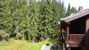 Eine Holzhütte mit Balkon, umgeben von einem Wald.