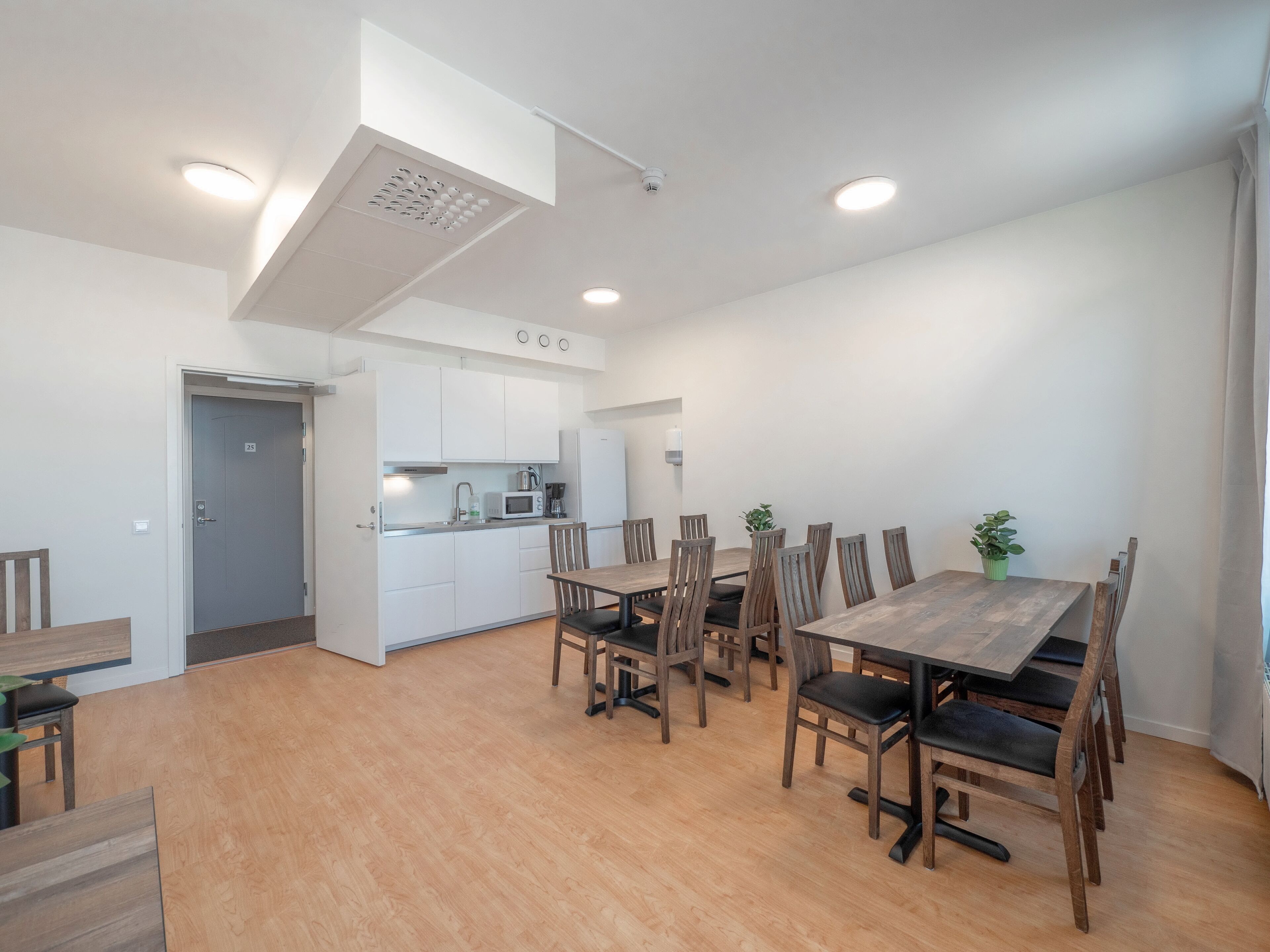Una cucina moderna con mobili bianchi, un forno a microonde e una macchina da caffè.