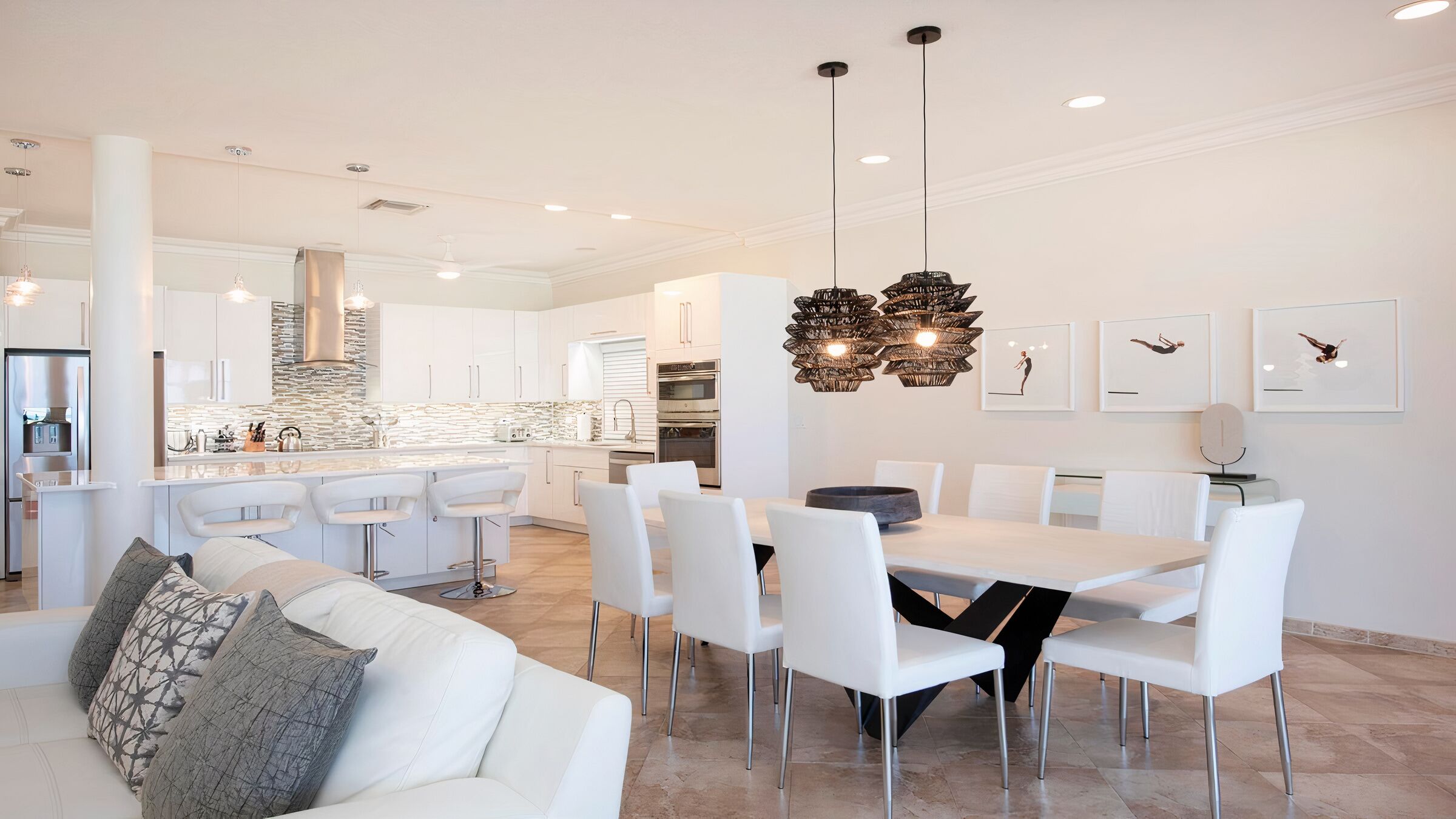Una cocina moderna con armarios blancos, una isla central y electrodomésticos de acero inoxidable.