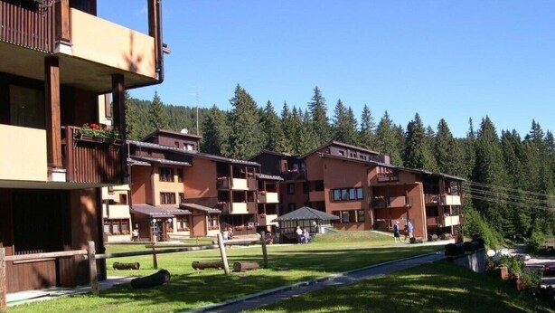 A hotel with multiple balconies, a central courtyard, and a forested background. - Residence Rio Falzè ~ TWO-ROOM APARTMENT TYPE A1 # 28 (Campo Carlo Magno)