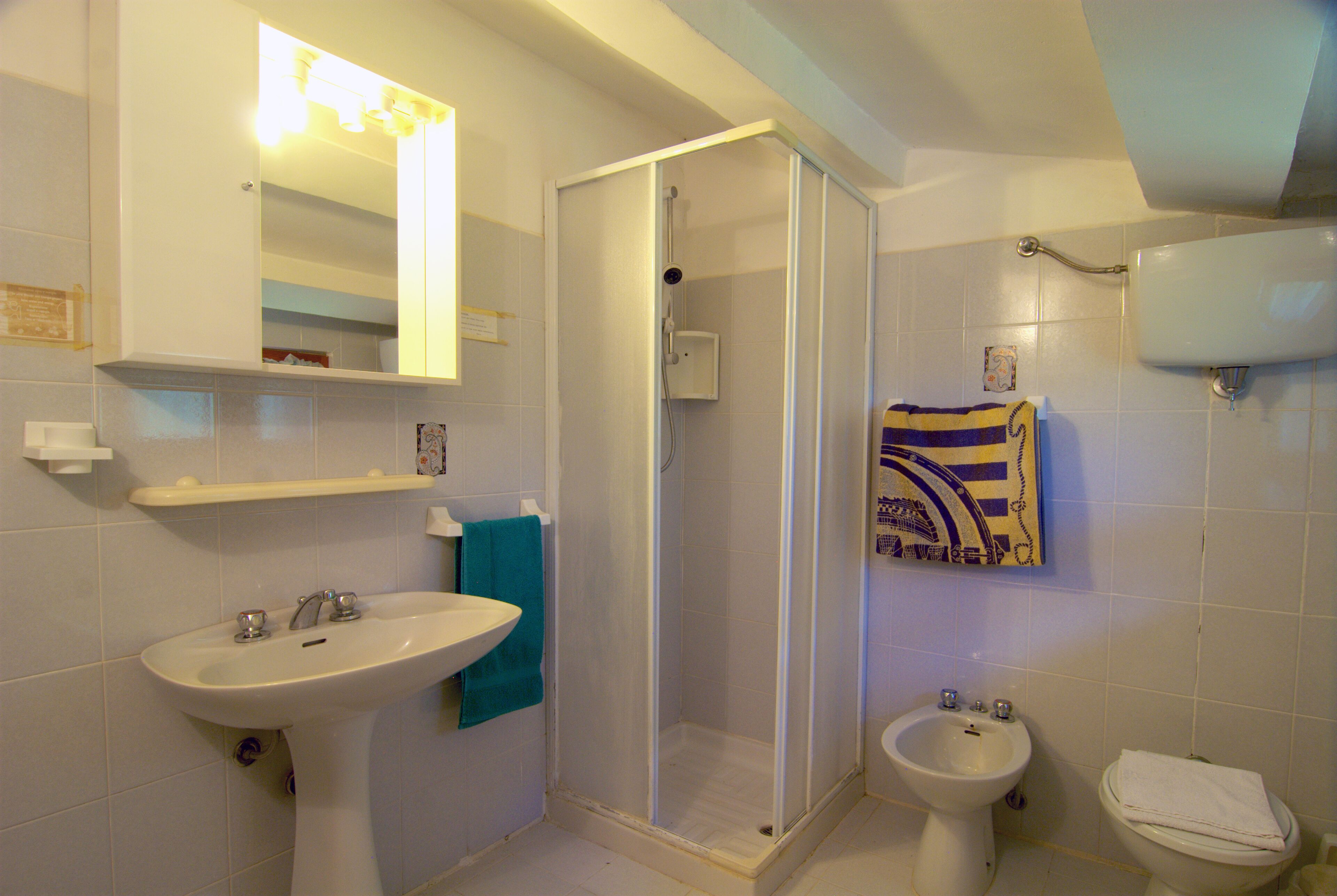 Une salle de bain équipée d’un lavabo, d’un bidet, de toilettes et d’une douche à parois de verre.