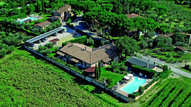An aerial view of a residential property with a swimming pool, multiple buildings, and a well-maintained garden. - La Dolce Collina (Castiglione del Lago)