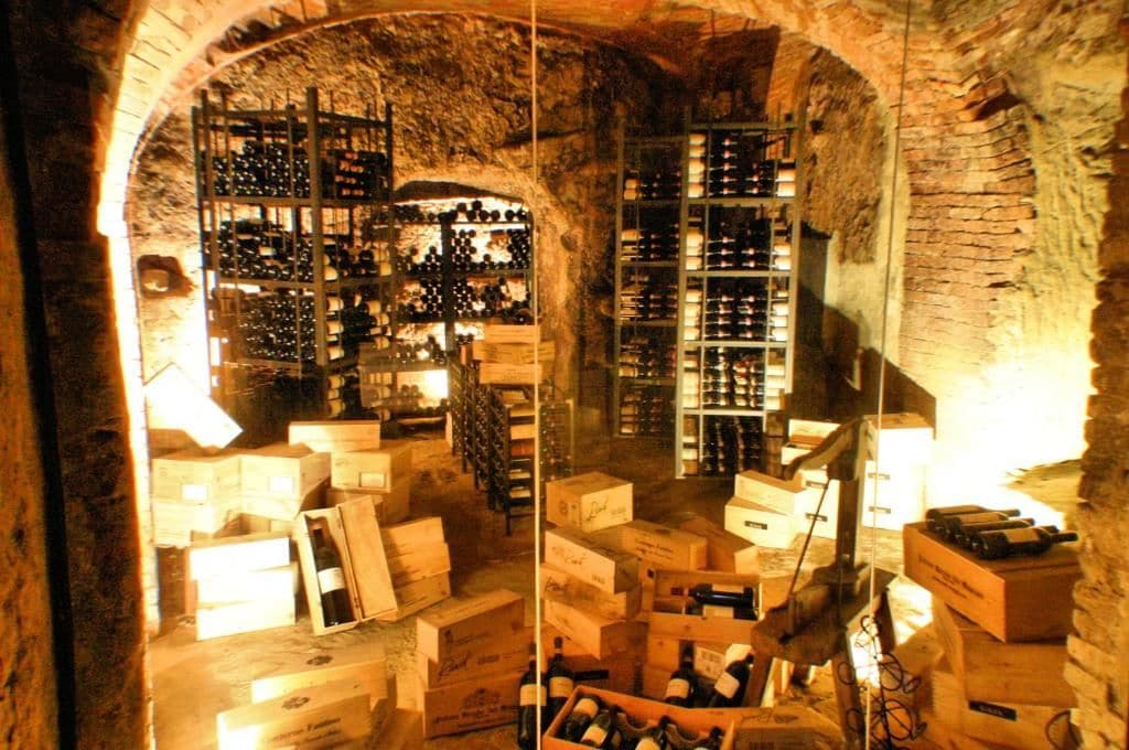 A wine cellar with wooden crates and shelves filled with bottles.