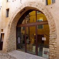 El exterior de un edificio con un arco de piedra y un letrero que dice 'LE CASE DELLA SARACCCA'.